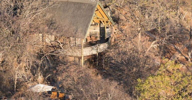 Rock-and-thatch chalet among the Ongava hills