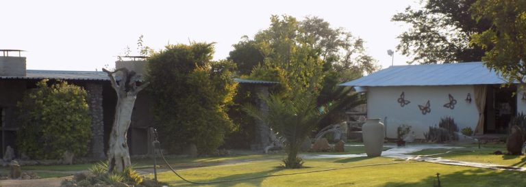 Eldorado Guesthouse and Camping – guesthouse rooms beyond the green lawn