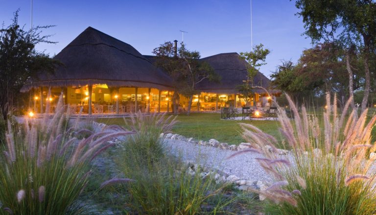 Thatched shared spaces at Mushara Bush Camp after sunset