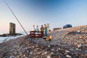Terrace Bay Namibia – anglers on the rocky beach at sunset