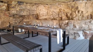 Outdoor dining table beneath canyon rock walls
