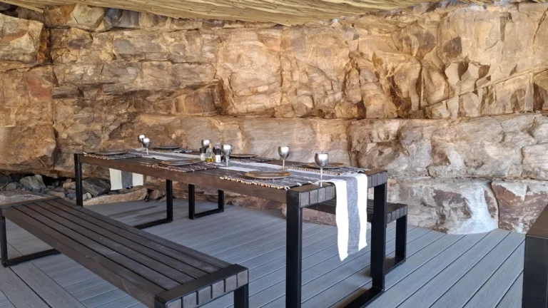 Outdoor dining table beneath canyon rock walls