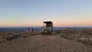 Safari vehicle on the canyon plateau at sunset