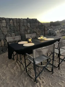 Outdoor dining table beside a stone wall at Fish River Lodge