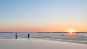 luxury lodge on the Skeleton Coast – guests watching sunset from coastal dunes