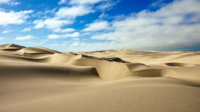luxury lodge on the Skeleton Coast – wind-shaped dunes beneath blue sky