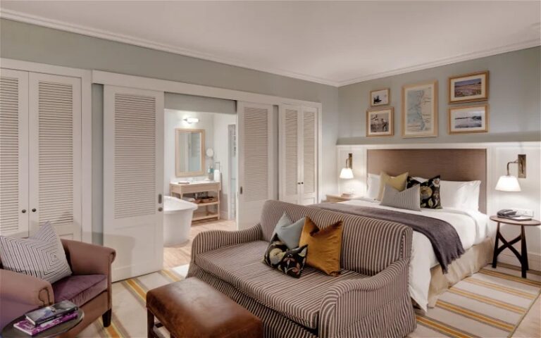 Strand Hotel Swakopmund – suite bedroom with sofa and open bathroom