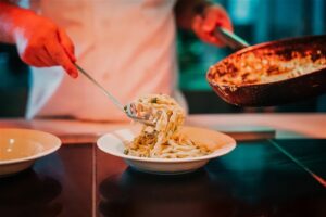 Swakopmund beachfront hotel – chef serving a hot pasta dish