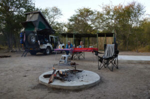 Khaudum camping – rooftop-tent campsite beside a fire ring