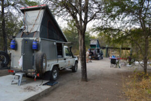 Sikereti Camp – two expedition vehicles at a sandy campsite