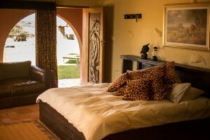 Mount Etjo Safari Lodge – king bed and lounge beside an arched doorway