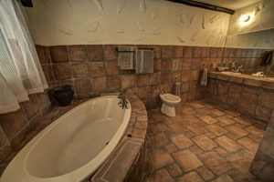 Okonjati Game Reserve lodge – spacious tiled bathroom with bathtub
