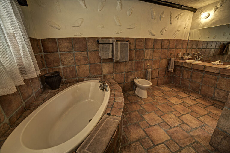 Okonjati Game Reserve lodge – spacious tiled bathroom with bathtub