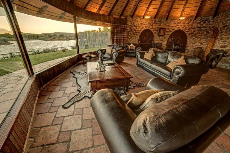 Okonjati Game Reserve lodge – stone-floored villa lounge and fireplace