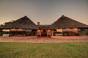 Mount Etjo accommodation – thatched lodge buildings at dusk