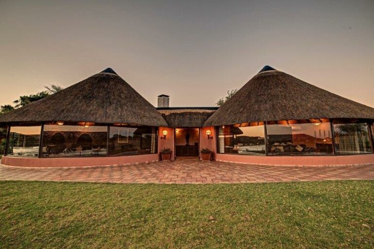 Mount Etjo accommodation – thatched lodge buildings at dusk