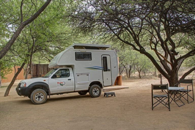 Namibia safari lodge – camper vehicle parked at a shaded site