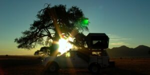 Namtib Desert Lodge – rooftop tent silhouetted at sunset