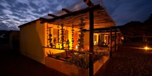 Namtib Desert Lodge – illuminated lodge veranda at dusk
