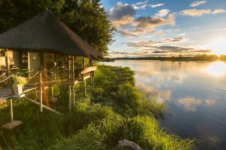 Nunda River Lodge – thatched bungalow glowing beside the river