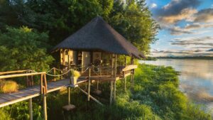 Divundu accommodation – thatched river bungalow on a raised platform