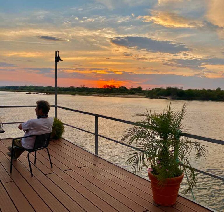 Kavango East lodge – guest watching sunset from the river terrace
