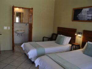 family accommodation in Lüderitz – twin bedroom with green accents