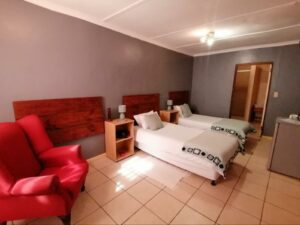 Lüderitz guesthouse – deluxe family room with red sofa
