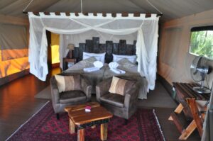Popa Falls accommodation – canvas chalet bedroom and lounge chairs