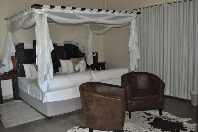 Divundu river lodge – bright chalet bedroom with four-poster bed