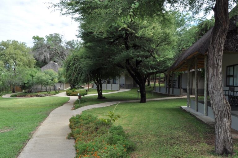 Popa Falls accommodation – green garden path between thatched rooms