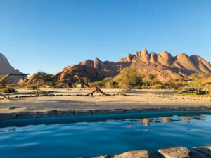 Spitzkoppe accommodation – Spitzkoppe granite panorama beyond a pool