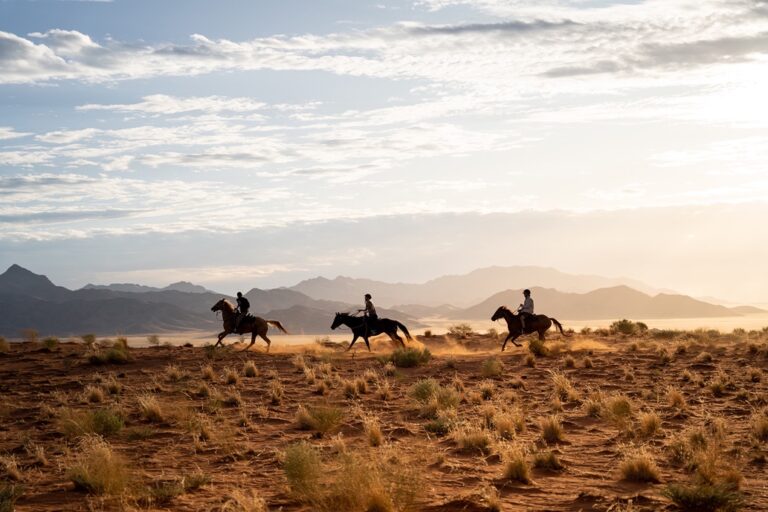 Wolwedans Namibia – horse riders crossing the desert plains