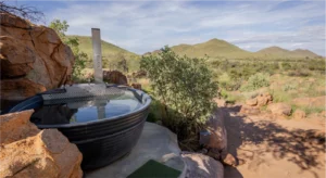 Wood-fired hot tub overlooking the mountain landscape at Nauams