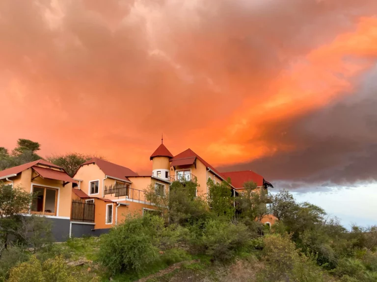 Ti Melen guesthouse in Windhoek beneath a dramatic sunset sky