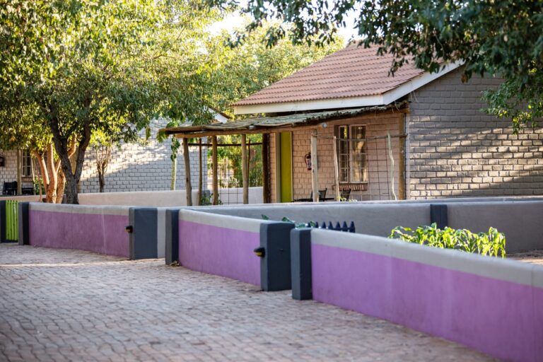Dining tables beside large windows at Damara Mopane Lodge