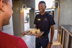 Etosha King Nehale staff member serving welcome drinks