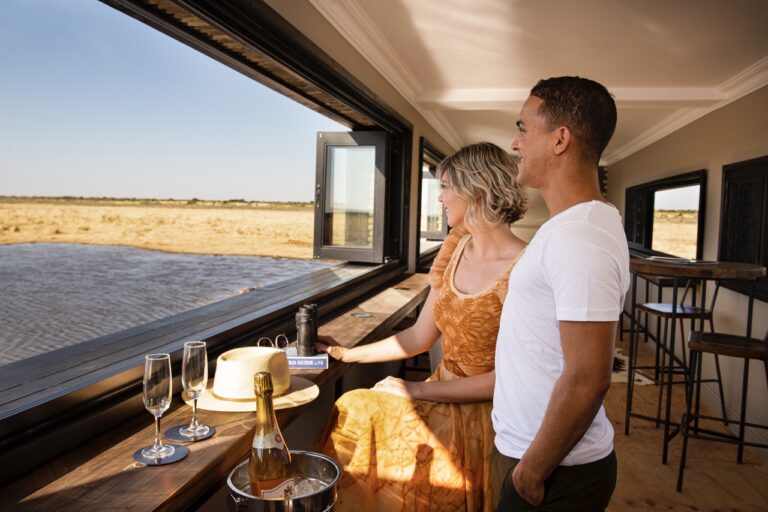 Couple watching the plains from the Etosha King Nehale waterhole hide