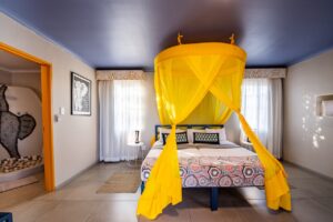 Double room with bright yellow mosquito net at the camp
