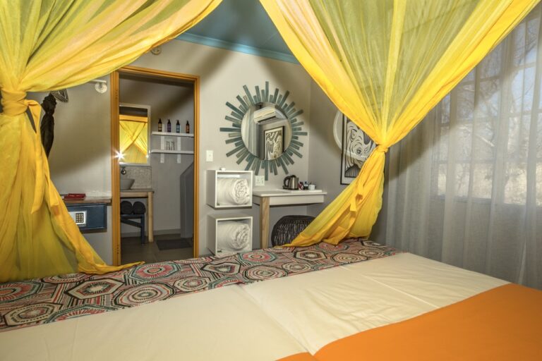 Etosha Safari Camp bed and adjoining bathroom