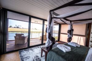 Bedroom opening onto the private deck at Namushasha River Villa