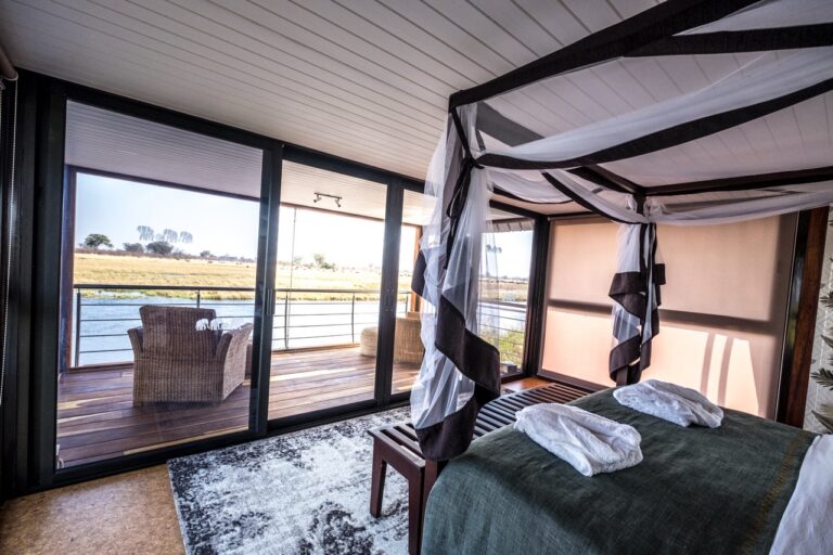 Bedroom opening onto the private deck at Namushasha River Villa