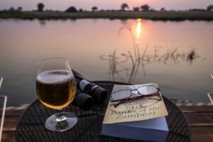 Sunset drink, binoculars and books at the private river villa
