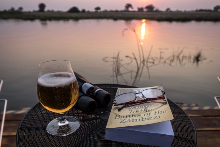 Sunset drink, binoculars and books at the private river villa