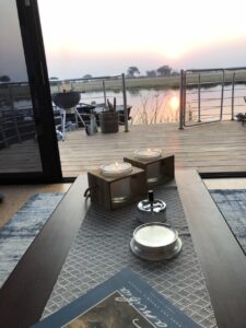 Dining table and waterside deck at Namushasha River Villa