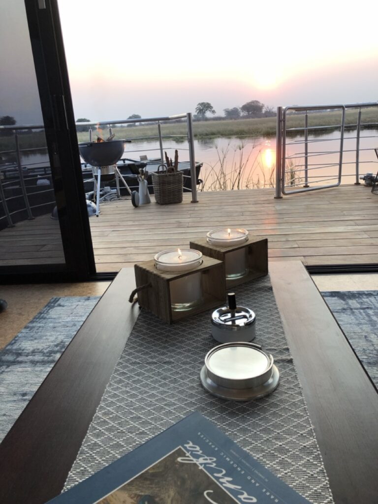 Dining table and waterside deck at Namushasha River Villa