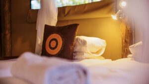 Bed and bedside lamp in an Omarunga Epupa-Falls Camp room