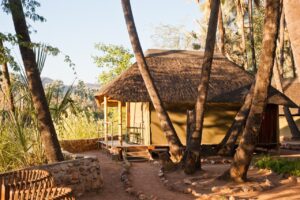 Thatched chalet exterior at Omarunga Epupa-Falls Camp