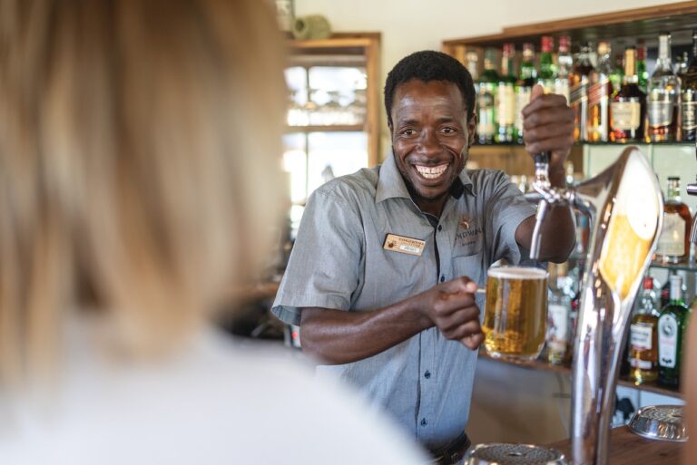 Friendly bartender serving drinks at Palmwag Lodge