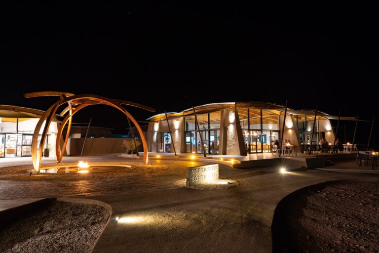 Illuminated Desert Grace lodge buildings in the evening